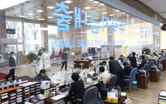 저금리와 부동산 금융규제가 완화로 1년 새 가계부채가 68조원 가까이 증가했다. 한국은행이 26일 발표한 '2014년 4분기 중 가계신용'에 따르면 지난해 말 기준으로 가계신용 잔액은 1천89조이었다. 1년 전보다 67조6천억원(6.6%)이 늘었다. 올해 추계 인구가 5천62만명인 점을 고려하면 국민 1인당 2천150만원 정도의 빚을 지고 있는 셈이다. 사진은 한 시중은행의 대출 창구    모습.